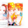 Illustration of a character with vibrant hair and earrings on a magazine page.