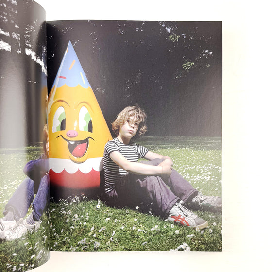 Person sitting on grass with a large pencil-shaped character in the foreground