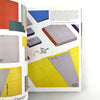 Open book showing colorful geometric design pages with text on a white background