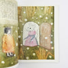 Illustrated book open to a page with a mouse and a child in a snowy scene.