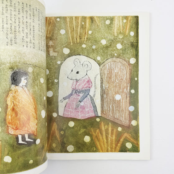 Illustrated book open to a page with a mouse and a child in a snowy scene.